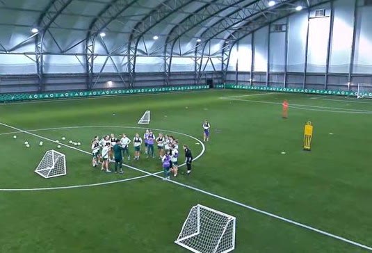 Jonathan talking to a group of players in the middle of the indoor pitch